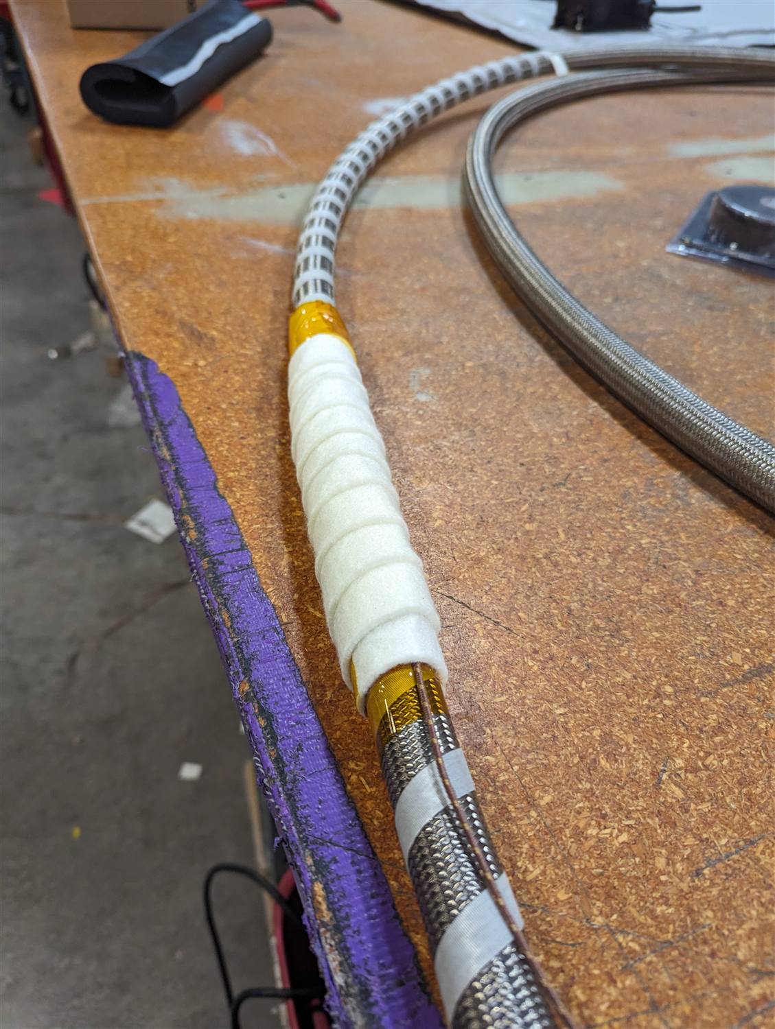 Meta-aramid felt insulation, a gold heat-shrink boot, and the transition to an overbraid jacket on a finished line