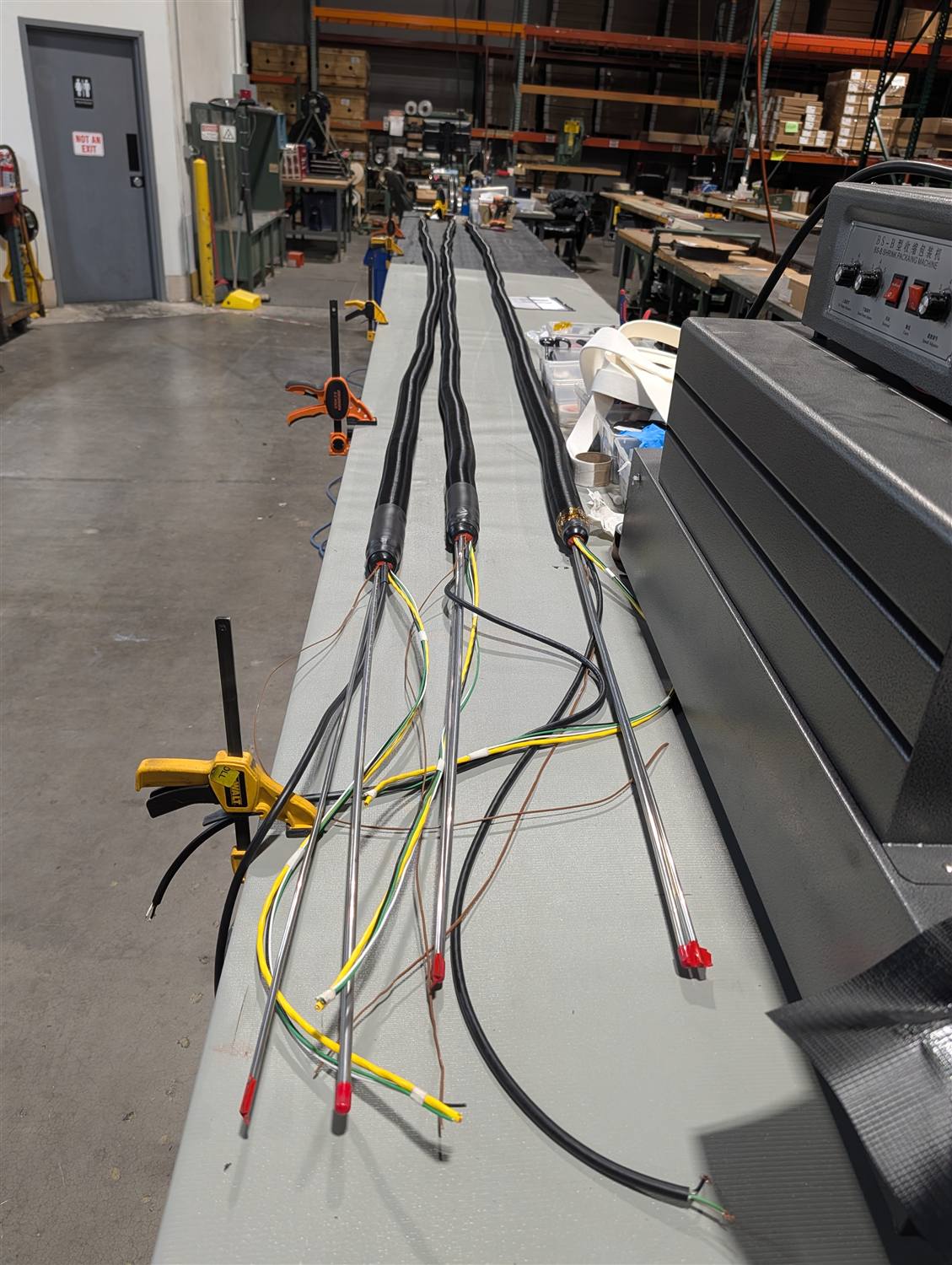 A wide shop-floor shot of three finished heated lines with wires fanning out